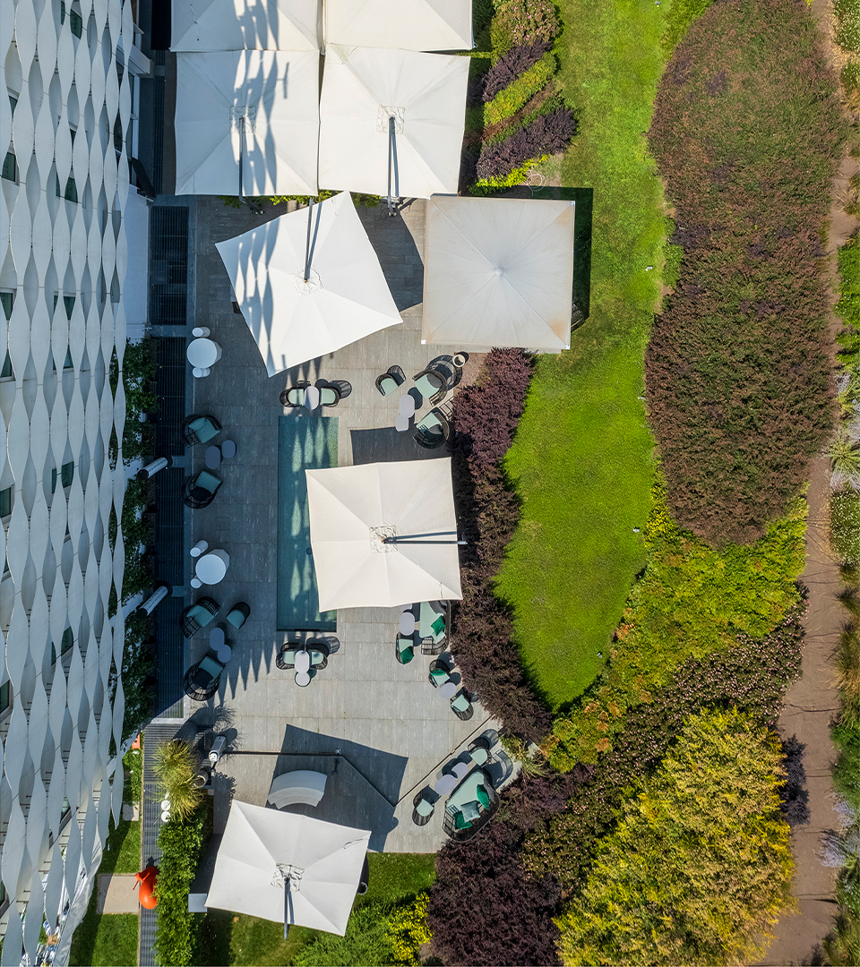 Aerial view of MOOM Hotel with lush garden and outdoor lounge bar