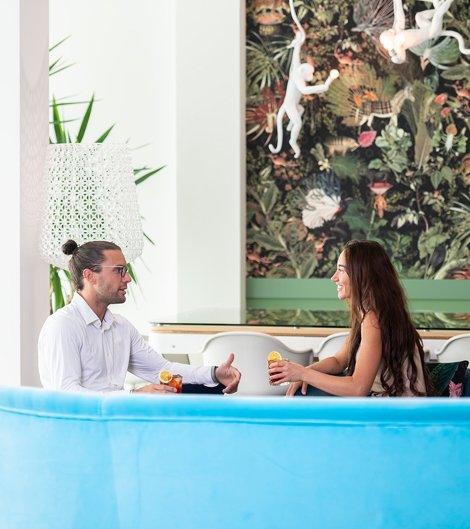 Coppia che brinda con un drink in un ambiente elegante, perfetto per eventi e feste