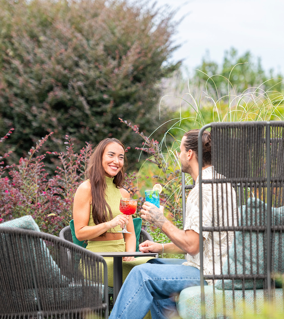 Coppia sorridente nel Lounge Bar esterno, location ideale per aperitivi e feste