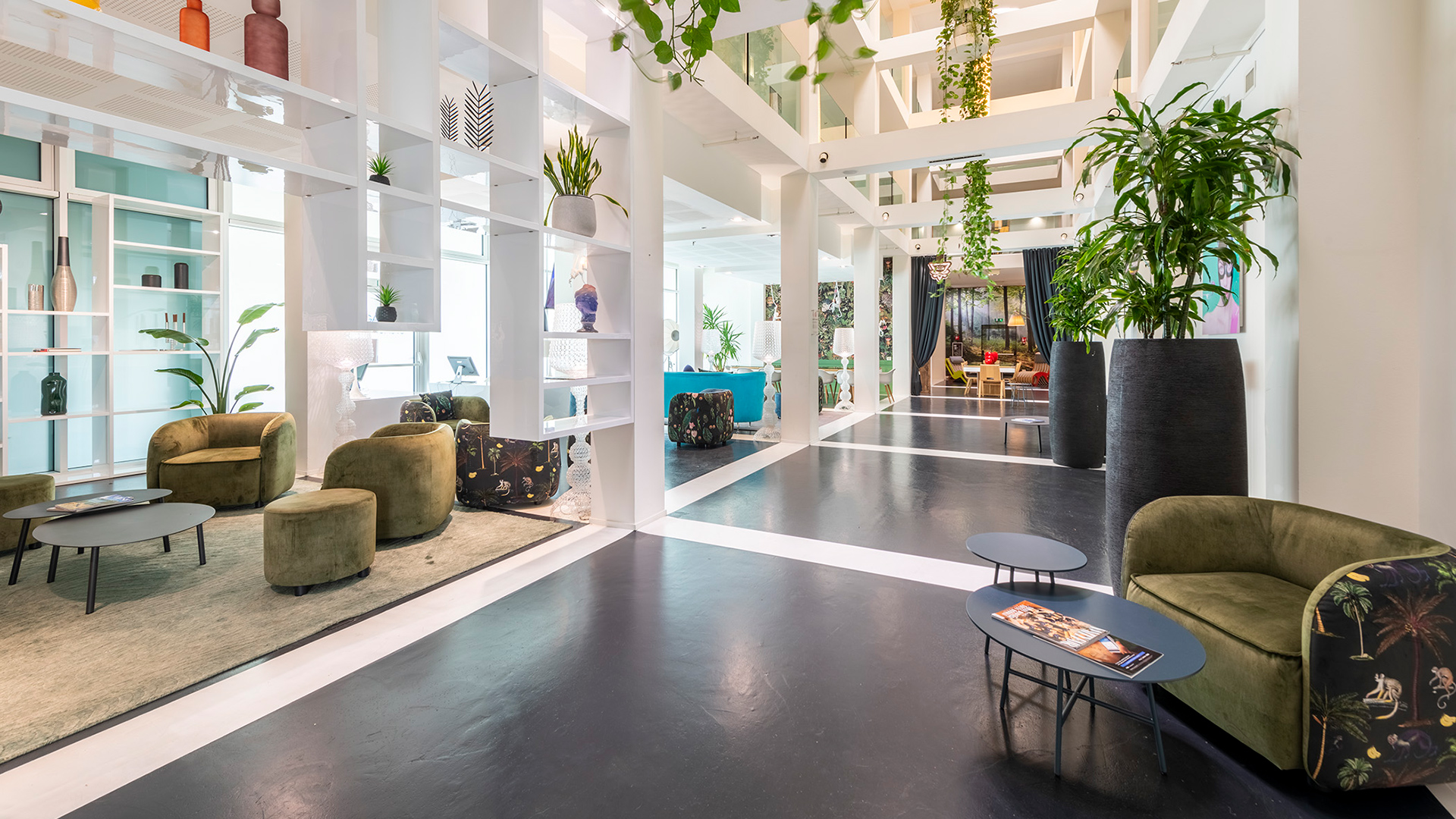 Lobby luminosa con ampie vetrate, piante verdi e poltrone accoglienti