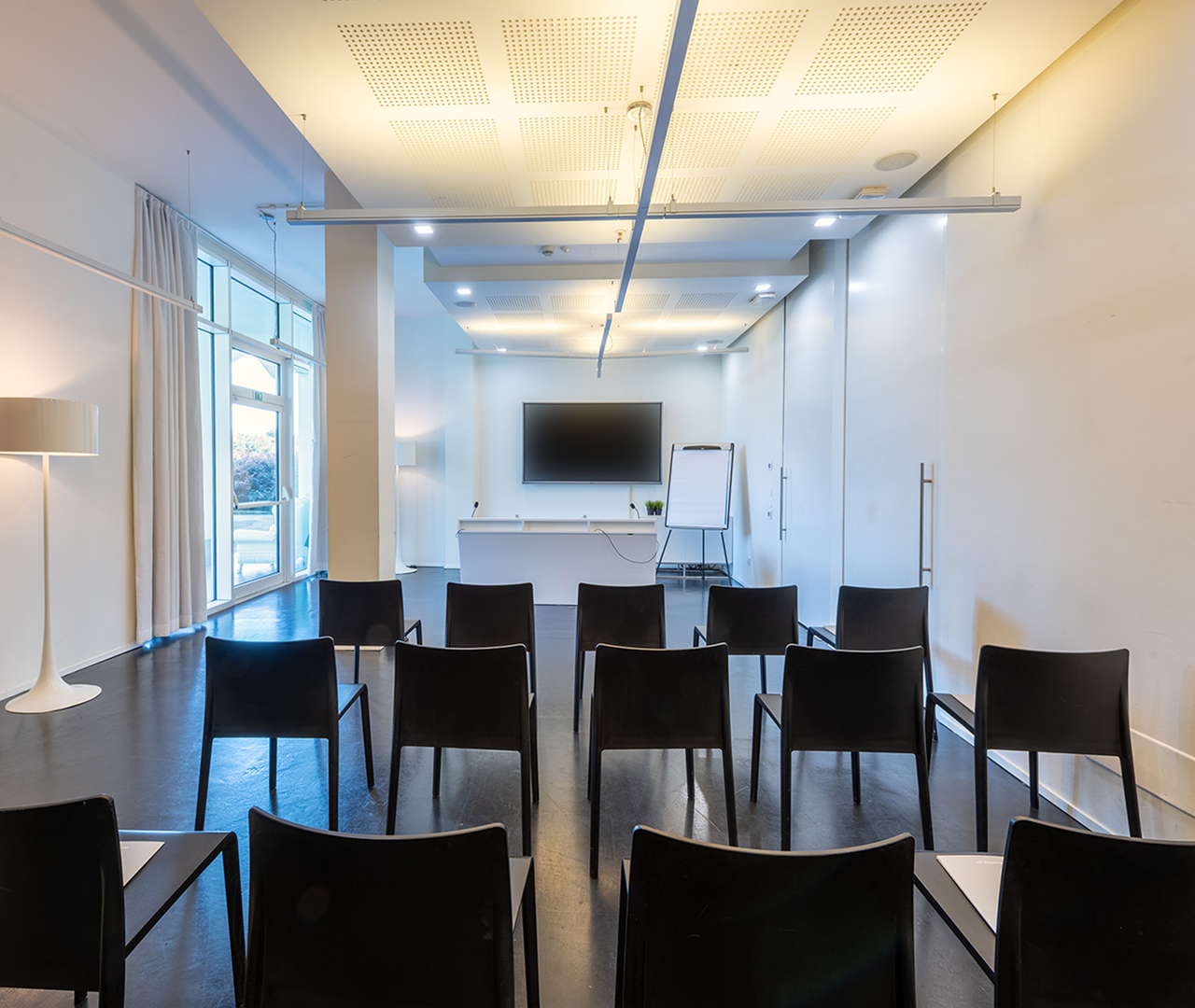 Sala meeting Baj con tavolo in legno, proiettore e sedute eleganti