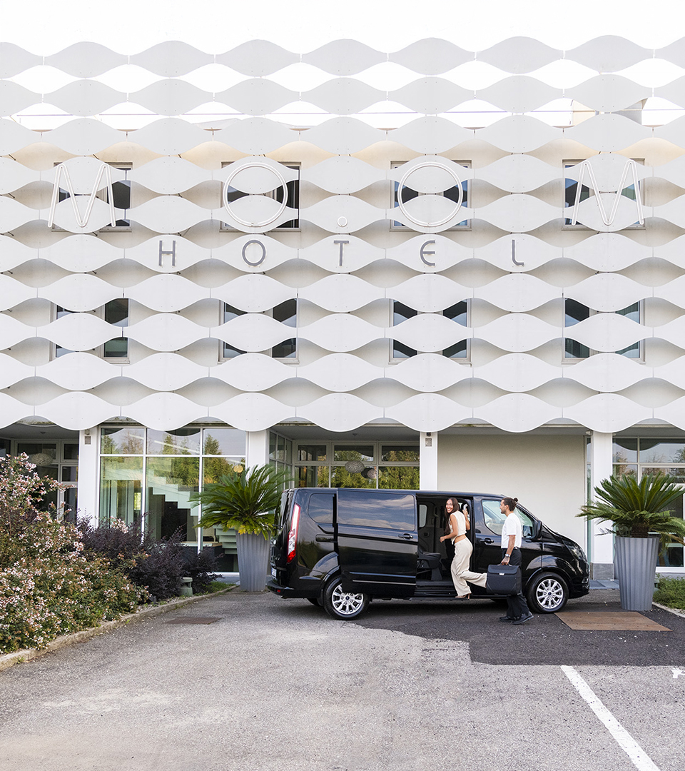 Ospite in partenza dal MOOM Hotel, che sale sulla navetta davanti all'ingresso dell'hotel