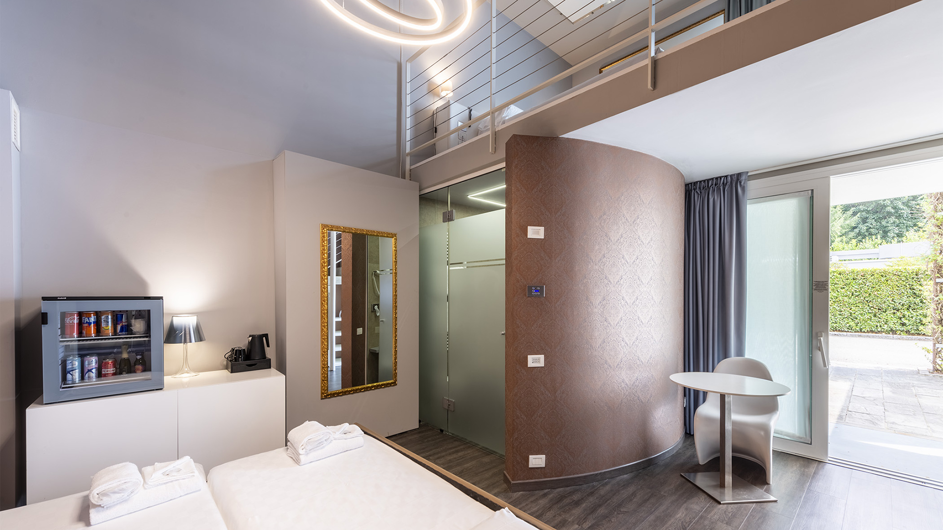 Lussuosa camera familiare a due piani con tre letti, ampia finestra sul verde, soffitto in vetro e specchi